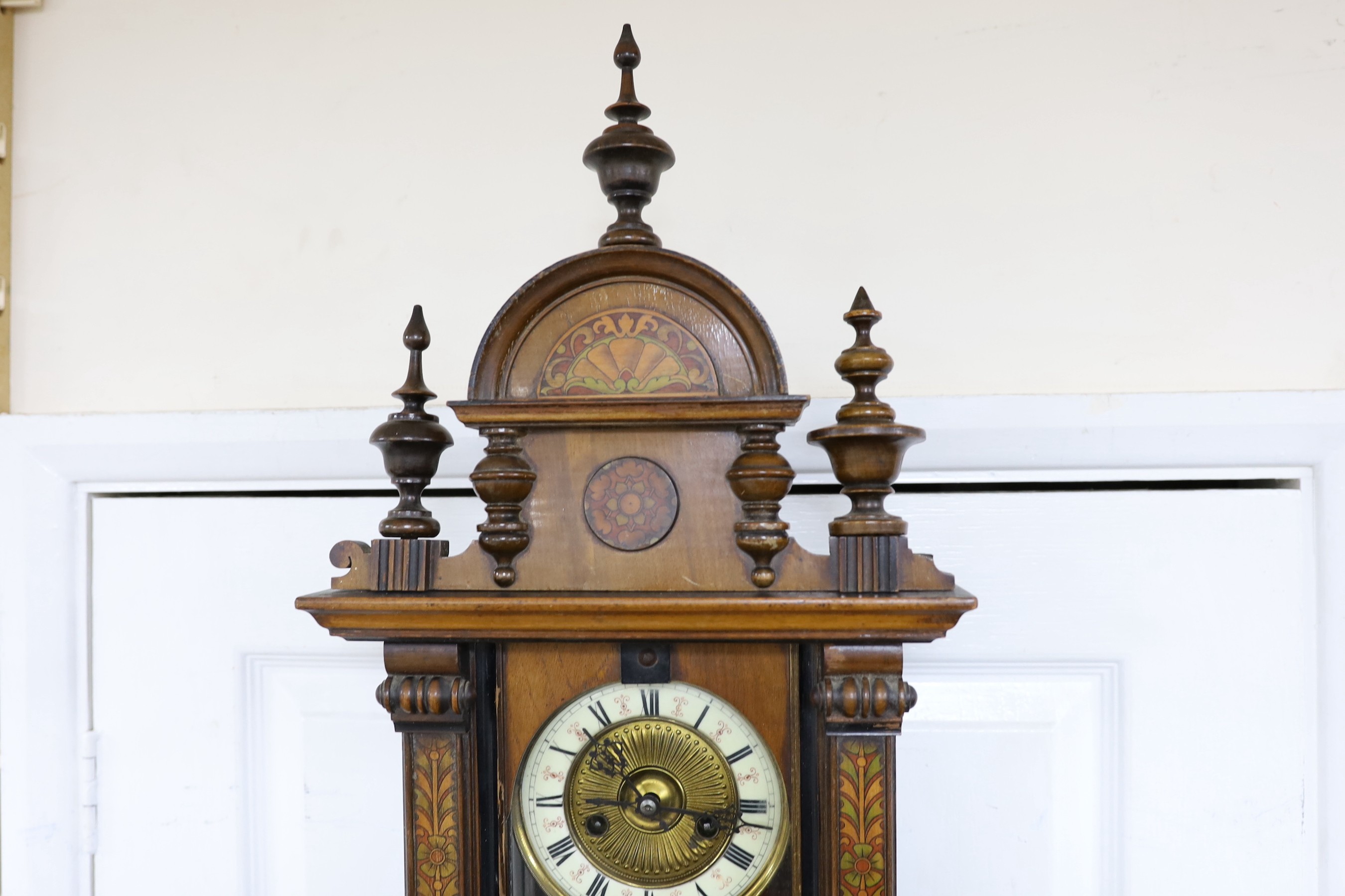 A small 19th century German wall clock with pendulum, 80cm long